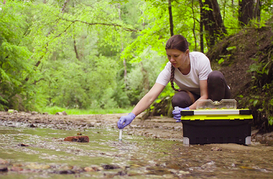 woman taking river water samples